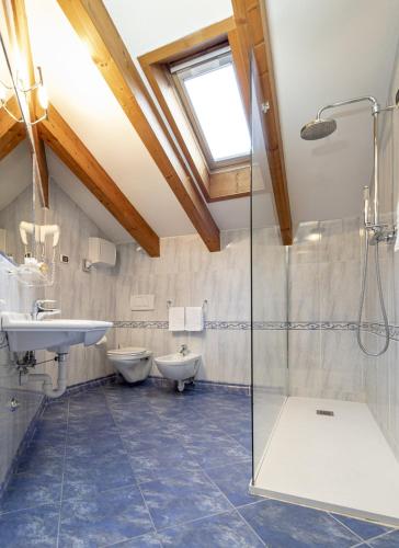 a bathroom with two toilets and a shower at Hotel Luis in Fiera di Primiero