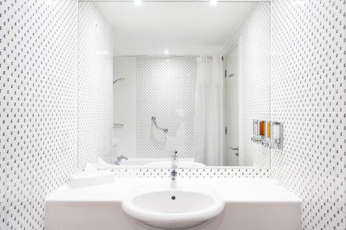 a white bathroom with a sink and a shower at Holiday Inn Hemel Hempstead M1, Jct. 8, an IHG Hotel in Hemel Hempstead