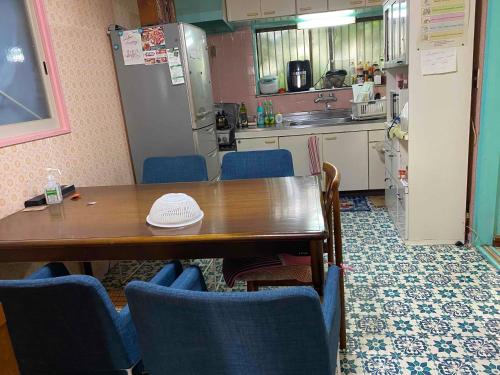 a kitchen with a wooden table and blue chairs at Mason 2 ,direct to Disney,Narita AP, Haneda AP,Asakusa,Sky Tree Tower, Ueno Ueno in Kamagaya