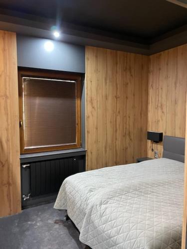 a bedroom with a white bed and a window at New York Pension in Dunajská Streda