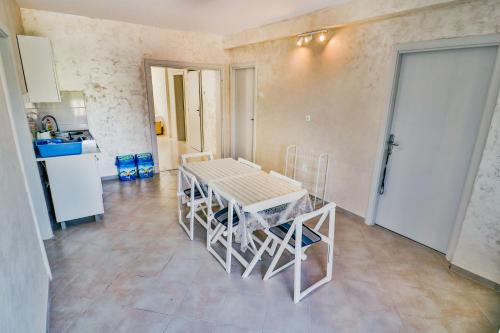 a kitchen with a table and chairs in a room at Ratac Eco Guest House in Sutomore