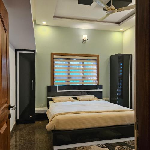 a bedroom with a large bed and a window at Bridge Point Home Stay in Kushālnagar