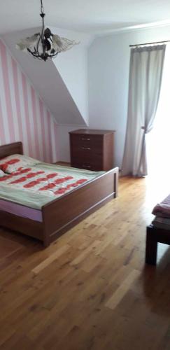 a bedroom with a bed and a dresser and a window at Zajazd Stok in Górecko Stare