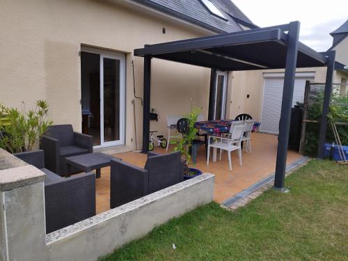 a screened in patio with a table and chairs at Entre Terre et Mer in Saint-Méloir-des-Ondes