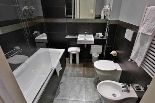 a bathroom with a tub and a toilet and a sink at Boutique Hotel Calzavecchio in Casalecchio di Reno