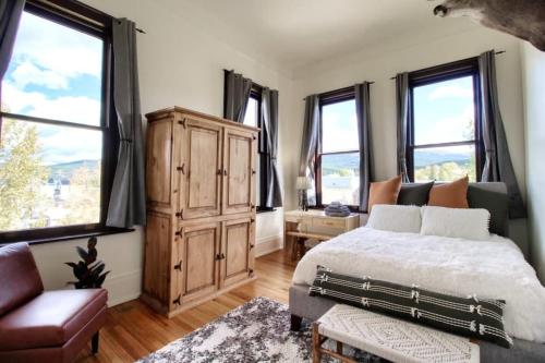 a bedroom with a large bed and windows at Historic Mountain Loft with GREAT Views in Leadville