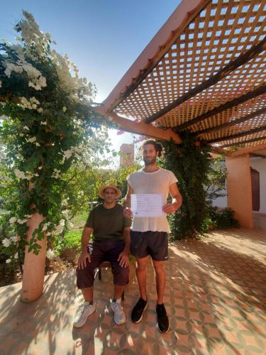 a man and a woman sitting under a pergola at Koom Martial Arts Retreat & Training Center Marrakech Morocco in Had Abdallah Rhiat