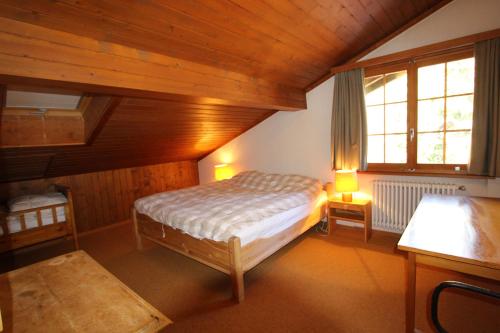 ein kleines Schlafzimmer mit einem Bett und einem Fenster in der Unterkunft Les Grands Prés 31 in Chateau-d'Oex
