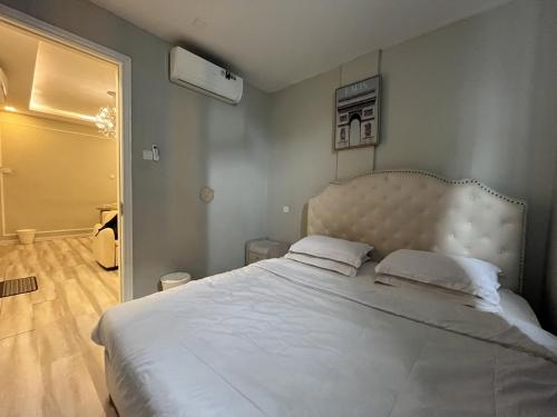 a bedroom with a large bed with white sheets at Casanova Penuin Batam in Nagoya