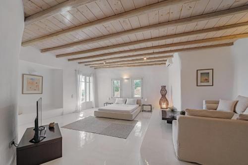 a living room with white walls and a wooden ceiling at Villa Zen Mykonos in Mýkonos City