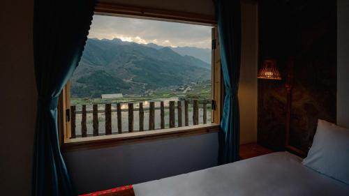 a bedroom with a window with a view of a mountain at Muong Hoa Eco Villa in Sa Pa