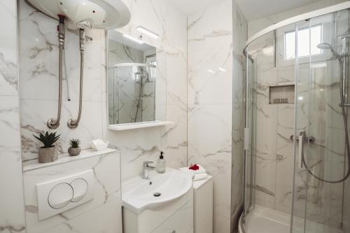 a white bathroom with a sink and a shower at villa Ana in Preko