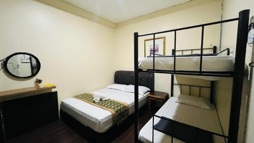 a small room with two bunk beds and a mirror at TC Maya Abaya Hotel in Kuantan