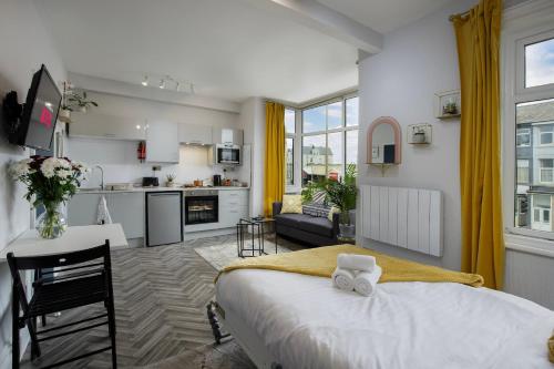 une chambre avec un grand lit et une cuisine dans l'établissement Lunar Stays, à Blackpool