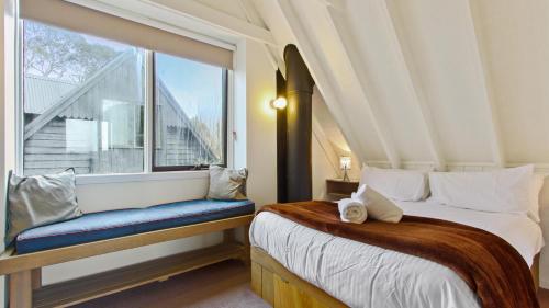 a bedroom with a bed and a large window at The Cubby in Dinner Plain