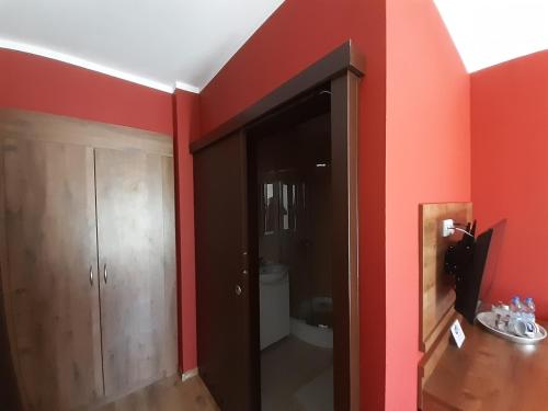a bathroom with a red wall and a toilet at Pensjonat Zielone Wzgórze w Bolesławowie in Stronie Śląskie