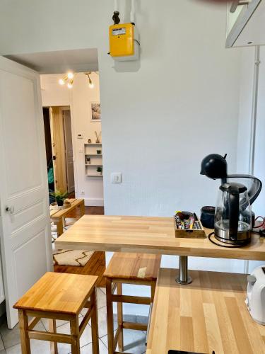 une cuisine avec une table en bois et quelques chaises dans l'établissement Akwaba Nancy, à Nancy