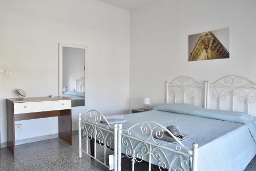 a bedroom with a bed and a desk and a mirror at VERETO apartaments Lecce in Lecce
