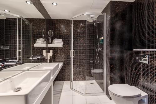 a bathroom with a shower and a sink and a toilet at Tallink Hotel Riga in Rīga
