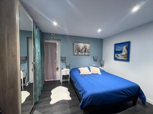 - une chambre bleue avec un lit et un miroir dans l'établissement Le Dramont, à Saint-Raphaël