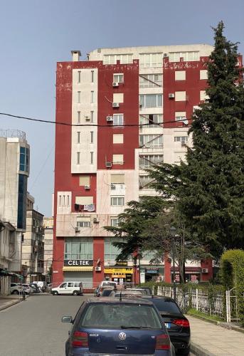 a car parked in front of a red building at Erlaiden Apartment in Shkodër