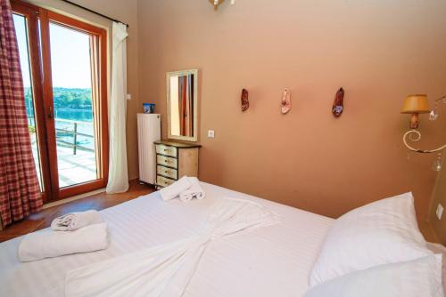 a bedroom with a large bed with towels on it at Levantes Houses in Vathi, Ithaka