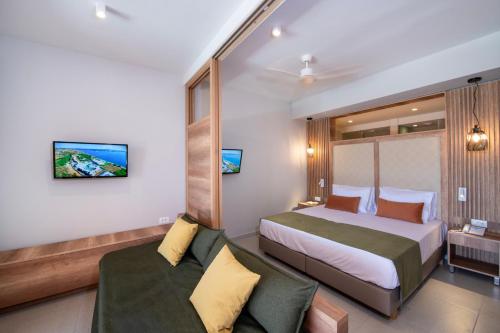 a hotel room with a bed and a couch at Kiani Beach Resort Family All Inclusive in Kalyves