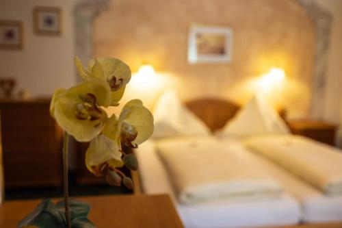 a vase with yellow flowers on a table in a hotel room at Appartementhaus Olympia Schlössl in Neustift im Stubaital