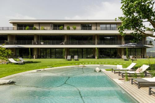 a house with a swimming pool in front of a building at Belia Lofts - ADULTS ONLY - Apartments in Appiano sulla Strada del Vino