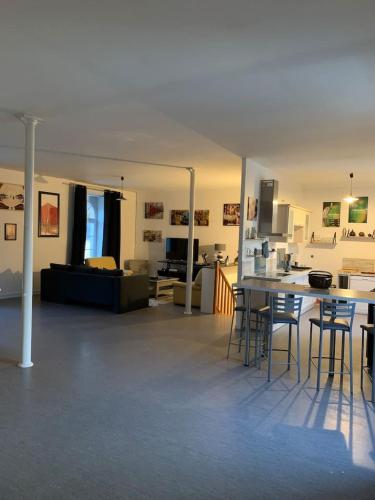un grand salon avec une table et des chaises dans l'établissement Appartement à Alençon, à Aleçon