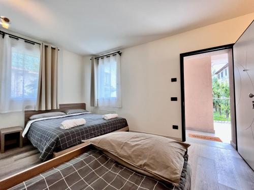 a bedroom with two beds and a large window at Nuovo appartamento in centro a Darfo Boario Terme in Boario Terme