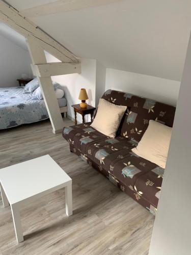 un salon avec un canapé et un lit dans l'établissement Appartement à Alençon, à Aleçon