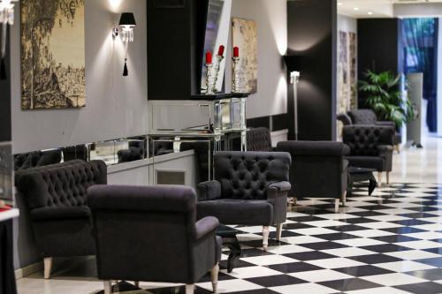 a waiting room with chairs and a checkerboard floor at Boutique Hotel Calzavecchio in Casalecchio di Reno