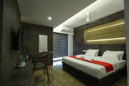 a bedroom with a large bed with a red blanket at D-Luxe Hotel in Cochin