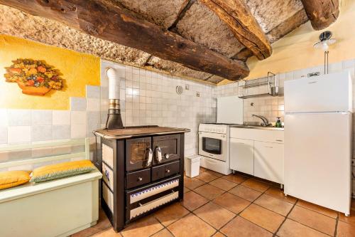 a kitchen with a stove and a refrigerator at Agriturismo Malga Riondera in Ala