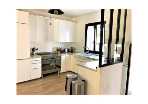 une cuisine avec des armoires blanches et un four à plaques de cuisson dans l'établissement Maison avec piscine bord de mer, à Marseille