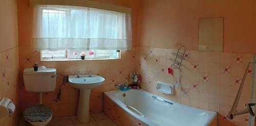 a bathroom with a sink and a tub and a toilet at 54 Martjie laan in Brits