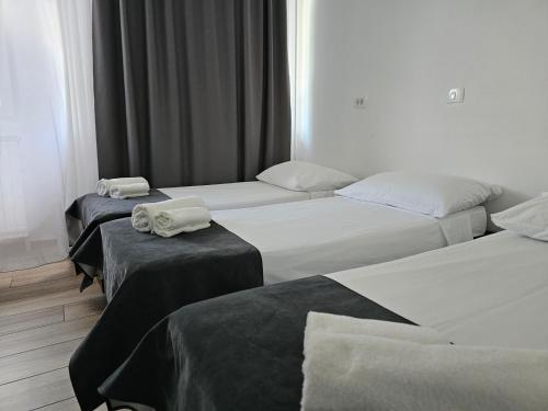 three beds in a hotel room with towels on them at Hotel Prunk in Sežana