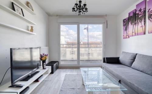 un salon avec un canapé et une grande fenêtre dans l'établissement Appartement proche de Paris et Disney, à Champigny-sur-Marne