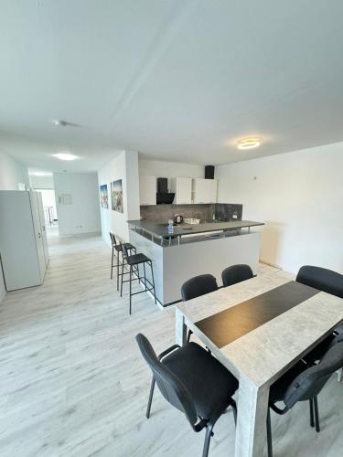 pokój ze stołami i krzesłami oraz kuchnią w obiekcie Frühling Apartment w mieście Bergisch Gladbach