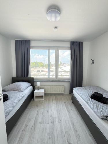 sypialnia z dwoma łóżkami i oknem w obiekcie Frühling Apartment w mieście Bergisch Gladbach