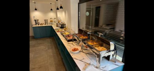 a kitchen with a counter with many trays of food at Ambassador & Ambassador Lux Apartments in Ulcinj