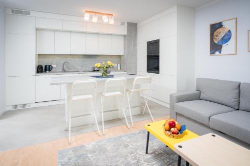 a kitchen and living room with a couch and a table at Centaurus 49 by RENT4YOU in Olsztyn