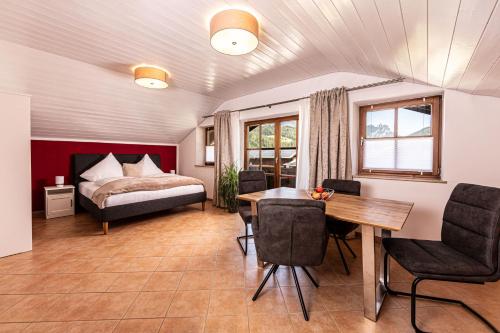 a bedroom with a bed and a table and chairs at Haus Familie Kosper Untersberger Kuschelnest in Bischofswiesen