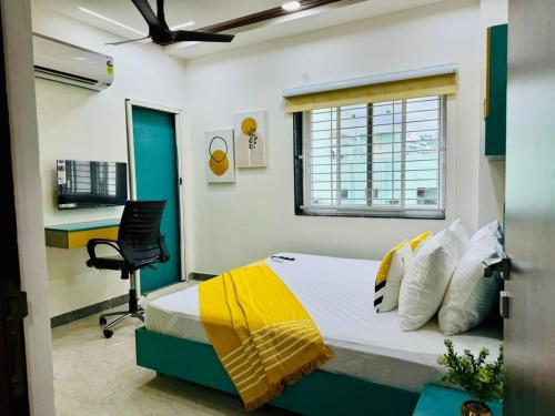 a bedroom with a bed and a desk and a window at Olive Service Apartments Gachibowli in Hyderabad