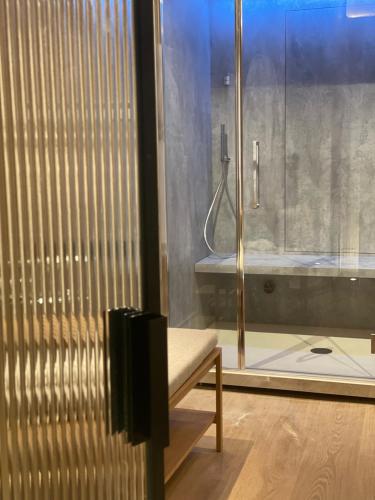 a bathroom with a shower and a bench next to a tub at Hotel L de Lutece - Notre-Dame in Paris