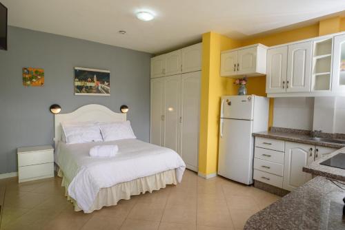 a small kitchen with a bed and a refrigerator at Casa Elalu in Quito