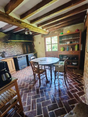 une cuisine avec une table et des chaises dans une pièce dans l'établissement Chez Catherine, à Saint-Michel-dʼHalescourt