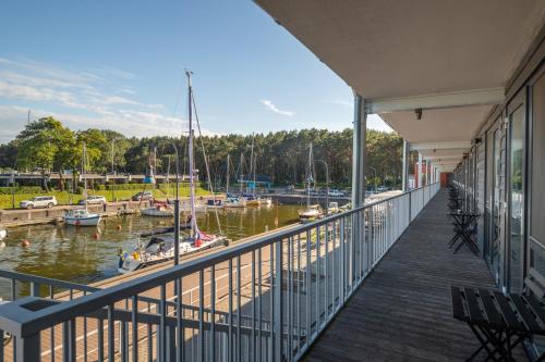 a balcony with a view of a marina at Smiltynės Jachtklubas in Klaipėda