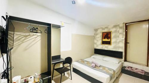 a small room with a bed and a mirror at TC Maya Abaya Hotel in Kuantan